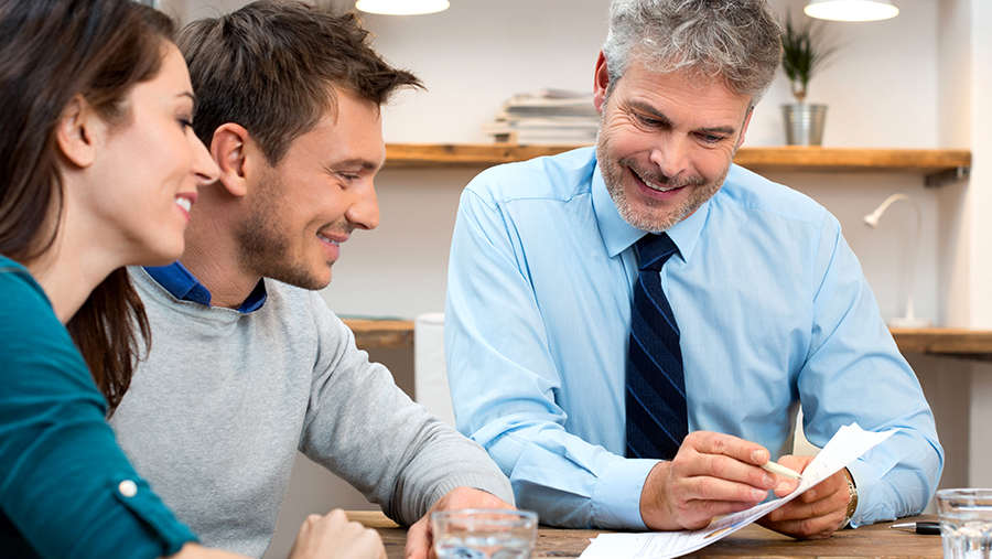 A business representative showing a document to a couple of customers
